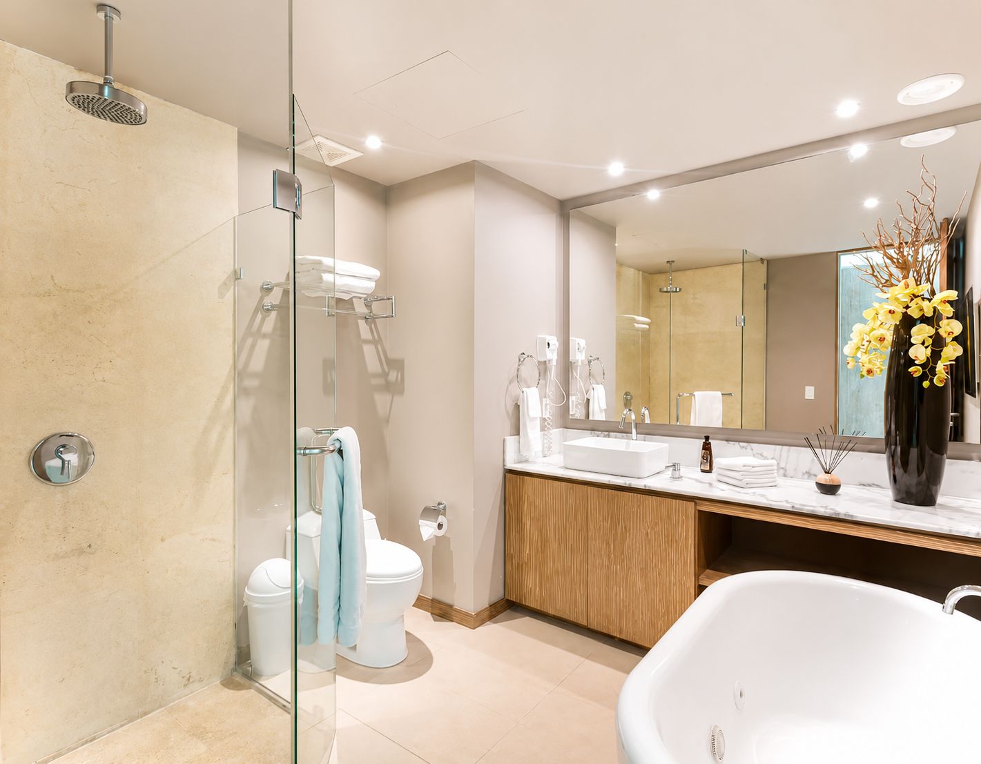 Un bagno moderno con doccia vetrata, vasca freestanding e un mobile vanitario con uno specchio grande.