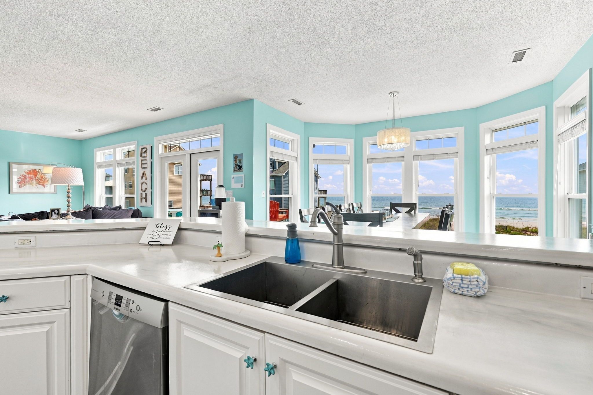A kitchen with a large window, a sink, and a dishwasher.
