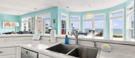 A kitchen with a large window, a sink, and a dishwasher.