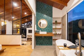 Ein modernes Badezimmer mit einem großen Spiegel, einem Holzkosmetikschrank und einer Badewanne.