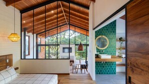 Een modern interieur met een groot raam, houten plafond en een badkamer met een groene betegelde achterwand in zeshoeken.