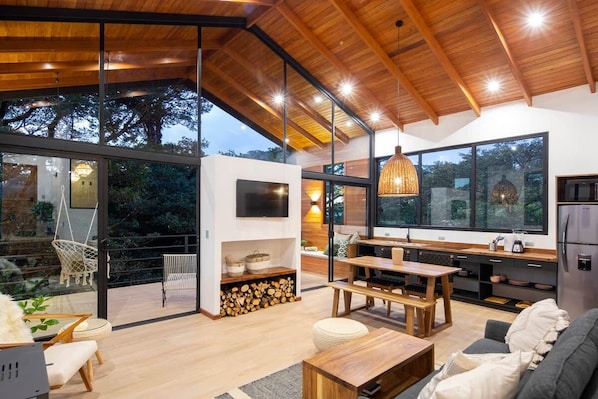 A modern kitchen with a large island, wooden ceiling, and large windows. - Casa Jaguar (3) (Monteverde)