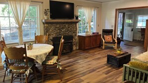 Uma sala de estar aconchegante com lareira, móveis de madeira e televisão na parede.