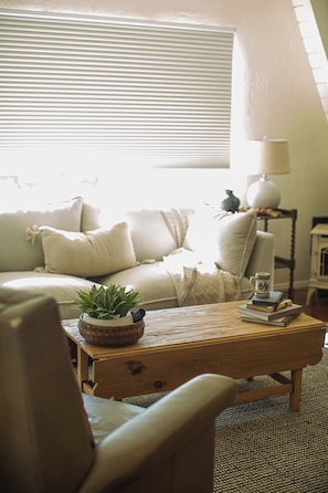 Una sala de estar acogedora con un sofá, un sillón y una mesa de centro.