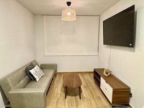 A small living area with a sofa, a coffee table, a TV, and a wall-mounted shelf. - Stunning Penthouse by Bosque Colomos, Pool, Gym & Fire Pit (Guadalajara)