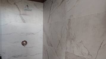 A bathroom with a shower, toilet, and sink.