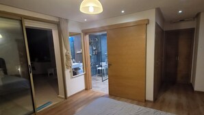 A bedroom with a large bed, a sliding door leading to a balcony, and a ceiling light. - Best Sea View in Morocco, Wheelchair Friendly, Plage des Nations, Rabat, Kénitra (Plage des Nations)