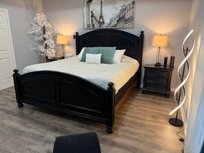 Ein Schlafzimmer mit einem schwarzen Bettgestell, einer weißen Bettdecke und zwei Nachttischlampen.