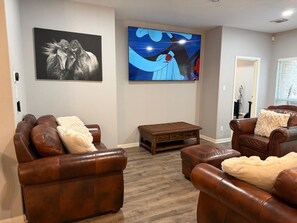 Ein Wohnzimmer mit Ledersofas, einem Couchtisch und Kunstwerken an den Wänden.