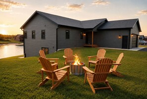 A modern house with a fire pit and Adirondack chairs on the lawn. - Rustic Retreat | Fall Lake Retreat | Fire Pit, Kayaks & Paddleboards (New Lisbon)