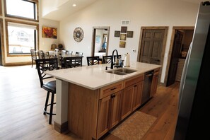 A modern kitchen with a large island, wooden cabinets, and a built-in dishwasher. - Rustic Retreat | Fall Lake Retreat | Fire Pit, Kayaks & Paddleboards (New Lisbon)