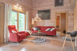Un intérieur moderne avec un canapé rouge, une table basse ronde et un plancher en bois.