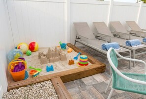 A beach-themed play area with sandcastles, beach toys, and a chair. - Saltwater Heated Pool | Kayaks |Golf Cart | Firepit | Beach (Palm Coast)