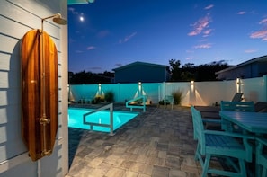 A backyard with a swimming pool, a wooden deck, and outdoor furniture. - Saltwater Heated Pool | Kayaks |Golf Cart | Firepit | Beach (Palm Coast)