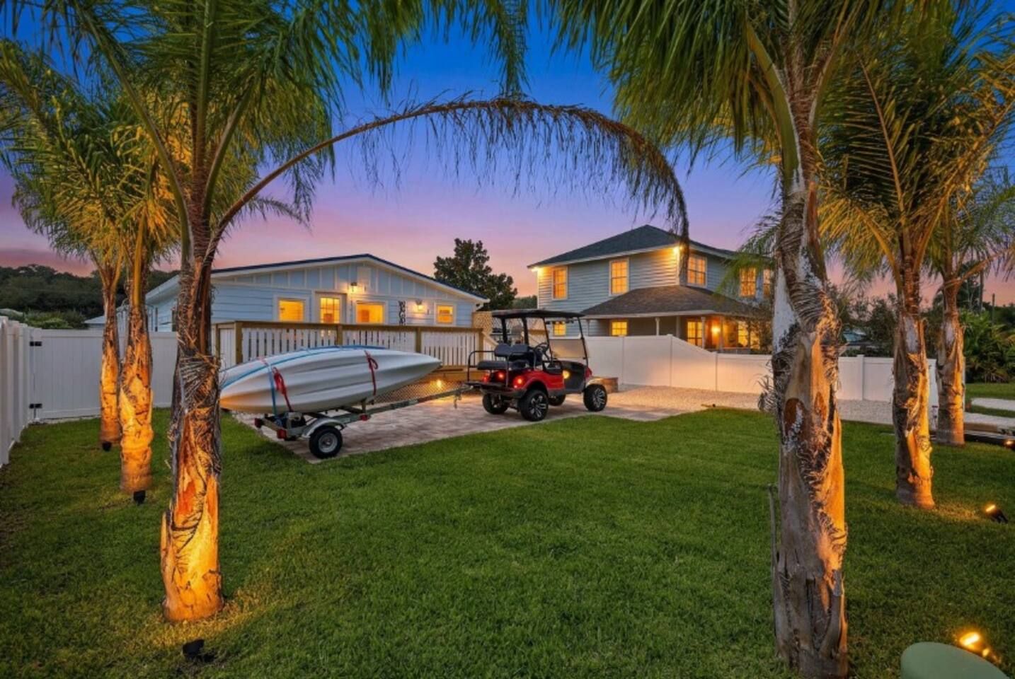 A residential property with a house, a boat on a trailer, and a golf cart.