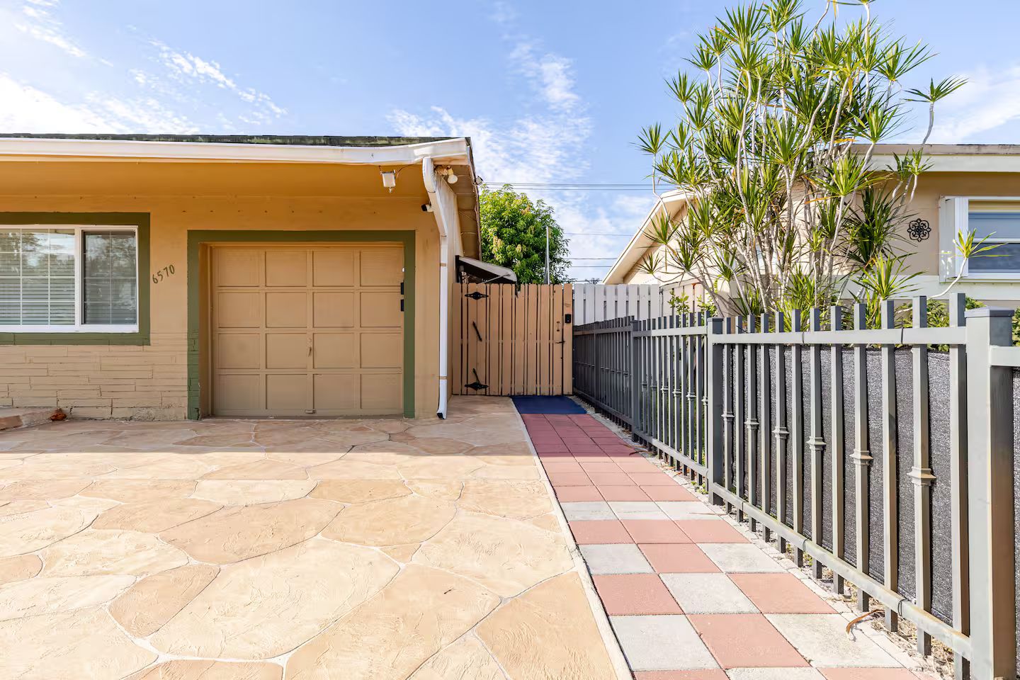 Propiedad residencial con garaje, entrada pavimentada y acceso mediante portón.