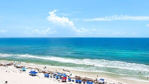 A beach with clear blue water, a sandy shore, and umbrellas. - Ocean Front Livingroom! By 30A, Beautifully Updated, Gated Community, 9th Floor (Panama City Beach)