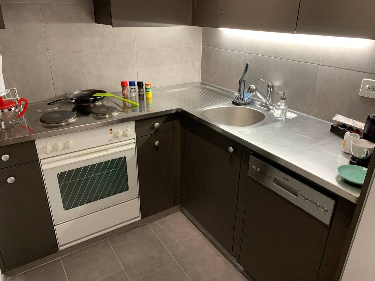 Eine moderne Küche mit Herd, Backofen, Spüle und Geschirrspüler.