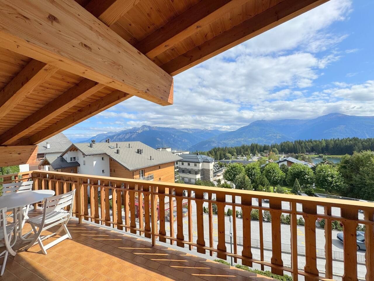Een houten balkon met uitzicht op een bergachtig landschap.