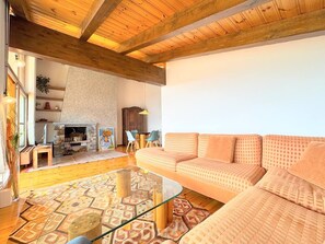 Una sala de estar con un sofá, una mesa de centro de vidrio y una chimenea.