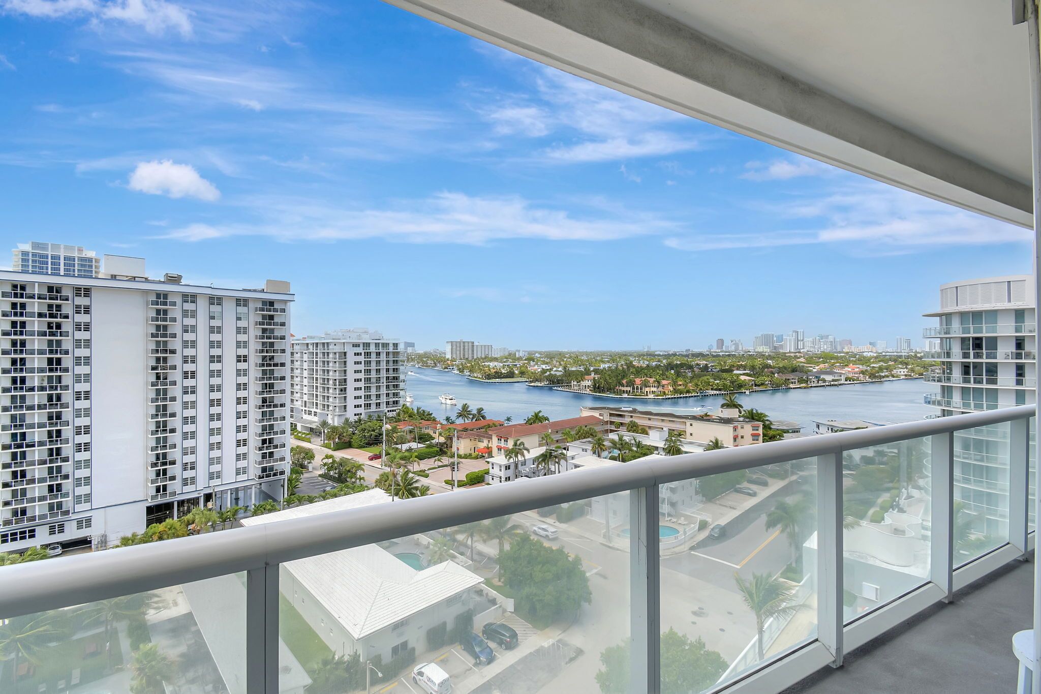 A high-rise building with a view of a marina and a river.