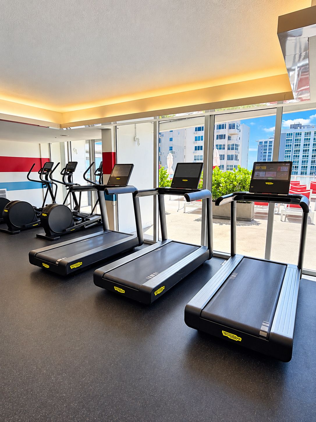 A gym with treadmills, elliptical machines, and stationary bikes.
