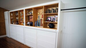 A garage with wooden shelving units displaying trophies, helmets, and sports memorabilia.