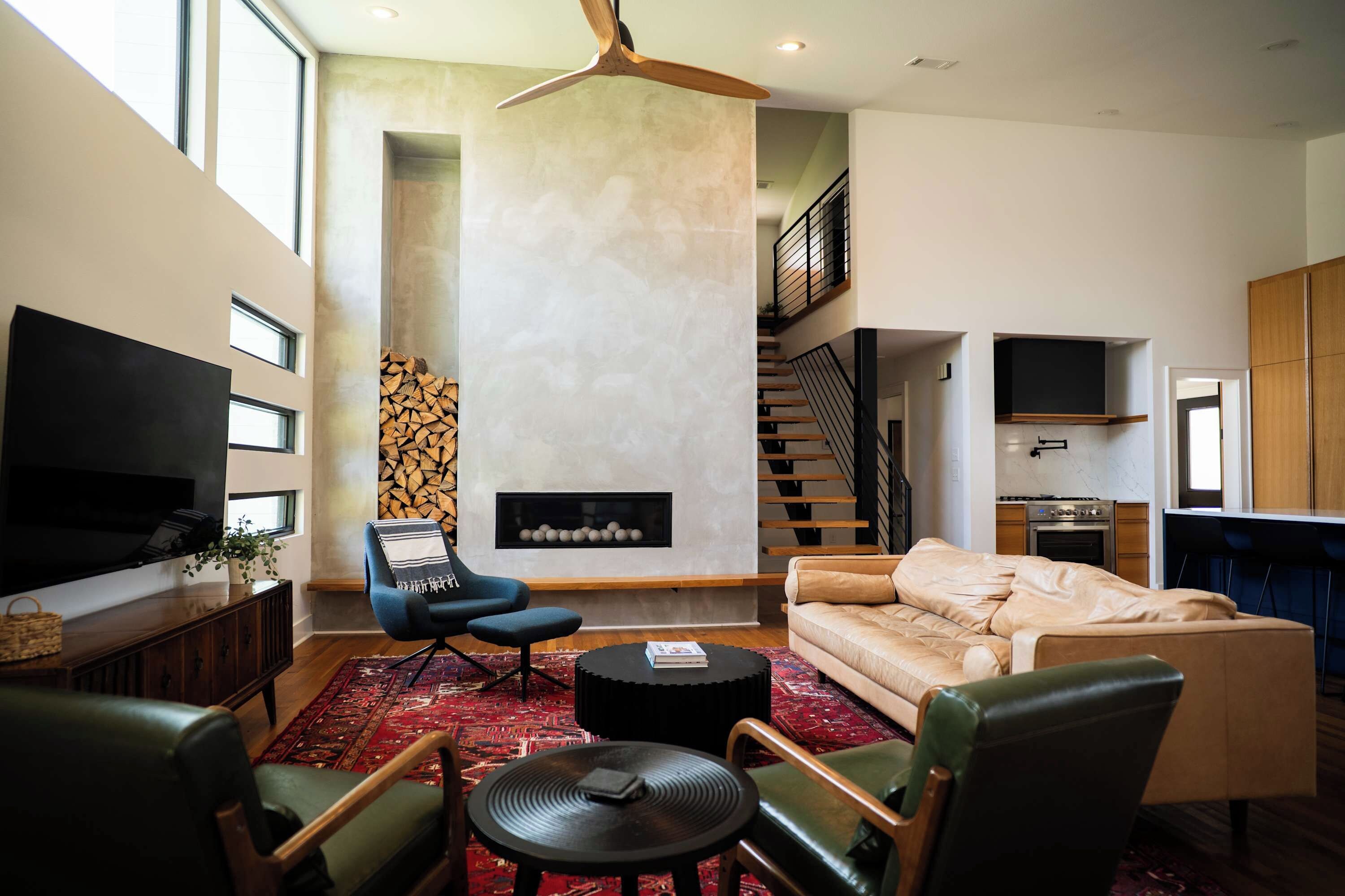 Un salon moderne avec une cheminée, un canapé, une table basse et un téléviseur.
