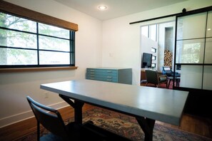 A room with a table, chairs, a window, a cabinet, and a view of the outdoors. - Mid Mod Lodge - Patio - Office - 0.5 mi UCA (Conway)