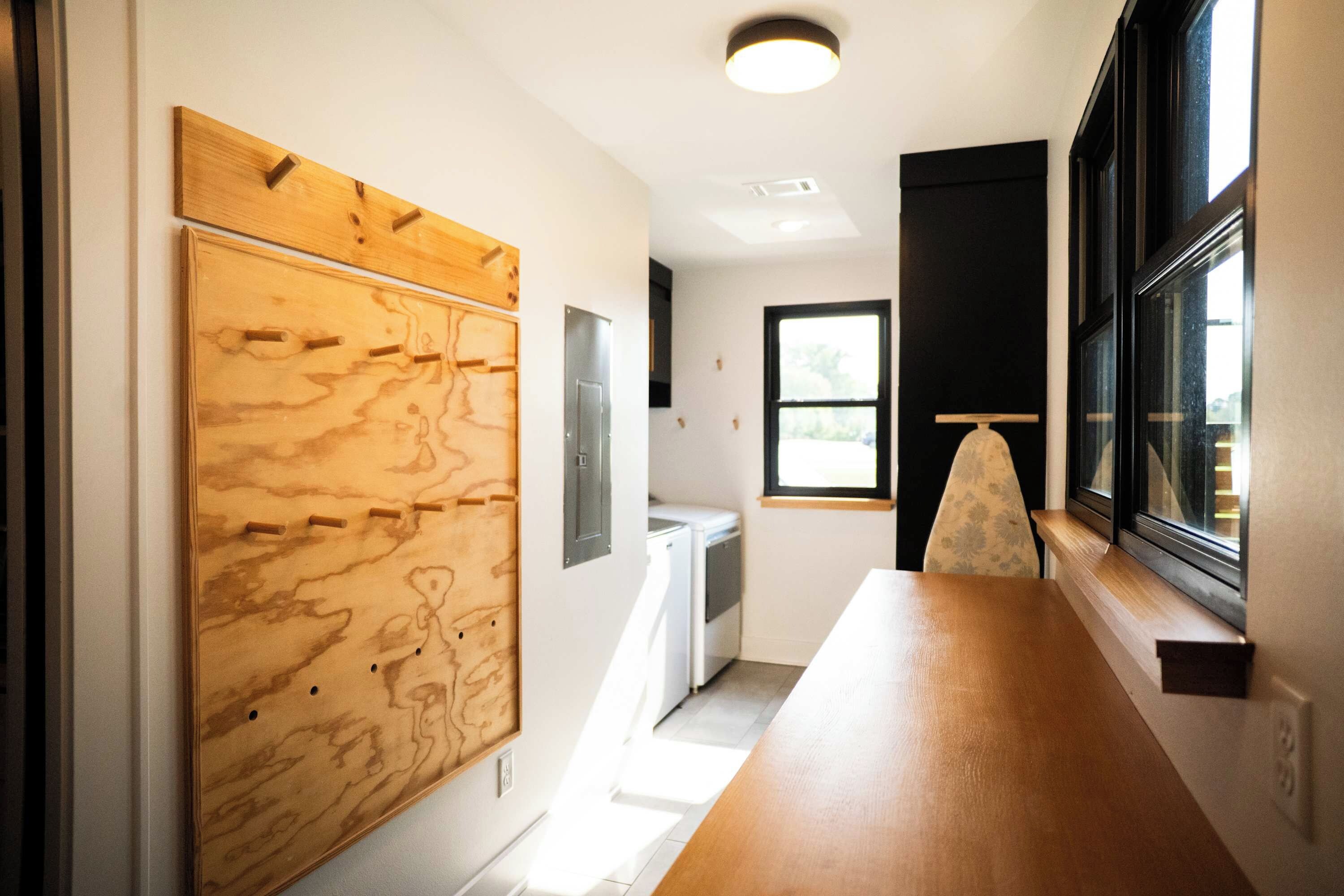 A modern interior with a wooden panel wall, a white appliance, and a window with a view.