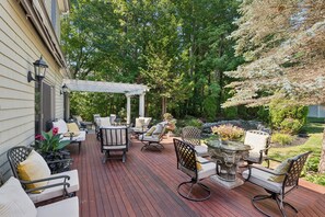 Eine Terrasse mit Gartenmöbeln, einer Pergola und einem Gartenbereich.
