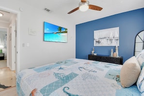 A bedroom with a bed, a ceiling fan, a TV, and artwork on the walls. - Heated Pool w/ Hot Tub • 10 min to Beaches • Pinellas Trail Access (Largo)