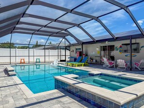 A covered outdoor swimming pool with lounge chairs and a barbecue area. - Heated Pool w/ Hot Tub • 10 min to Beaches • Pinellas Trail Access (Largo)