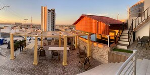 A rooftop terrace with a pergola, seating, and a view of the cityscape. - Whale Hill Family Duplex, Units A & B (Puerto Peñasco)