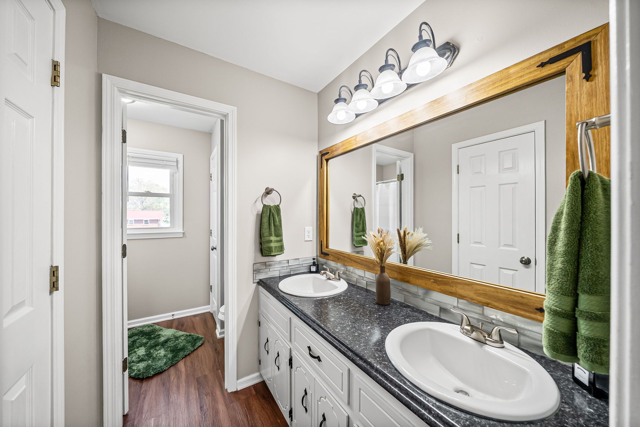 A bathroom with two sinks, a large mirror, and a shower.