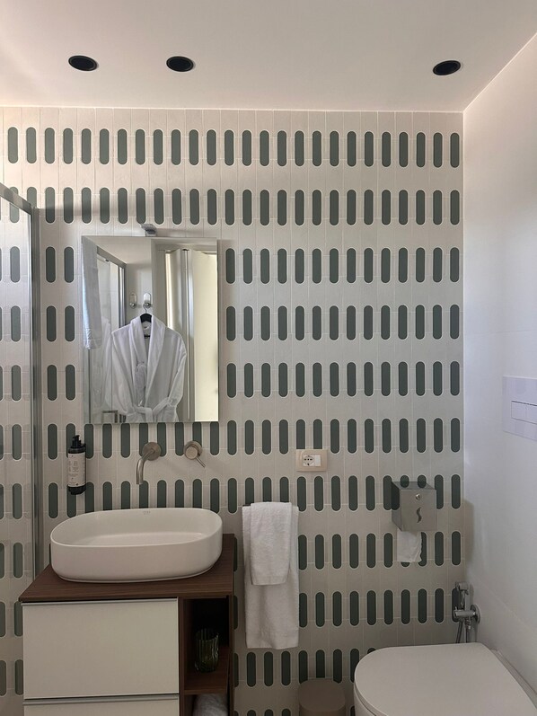 A bathroom with a sink, mirror, towel rack, and toilet. - Zahir Rooms & wellness (Trapani)