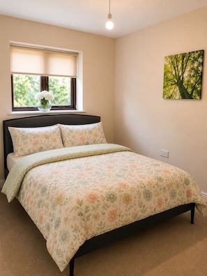 Una camera da letto con un letto, una finestra vista, una lampada a parete e un quadro.