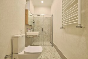 Ein kleines Badezimmer mit Toilette, Waschbecken und Dusche.
