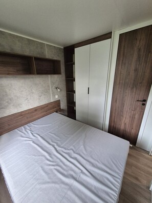 Quarto com cama, guarda-roupa e estante embutida.