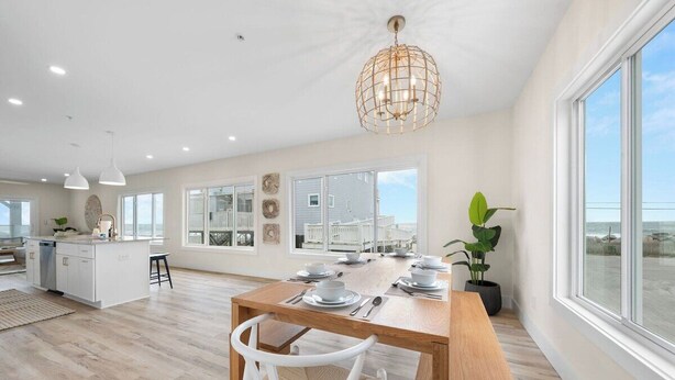 Una cocina amplia con comedor, ventanas grandes y vista a la playa.