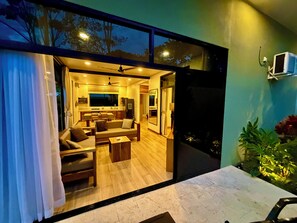A modern interior with a living area, kitchen, and dining space. - Awesome 4-bedroom estate with AC in charming Puerto Viejo (Puerto Viejo)