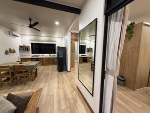 A modern kitchen with a dining area, wooden flooring, and a large mirror. - Awesome 4-bedroom estate with AC in charming Puerto Viejo (Puerto Viejo)