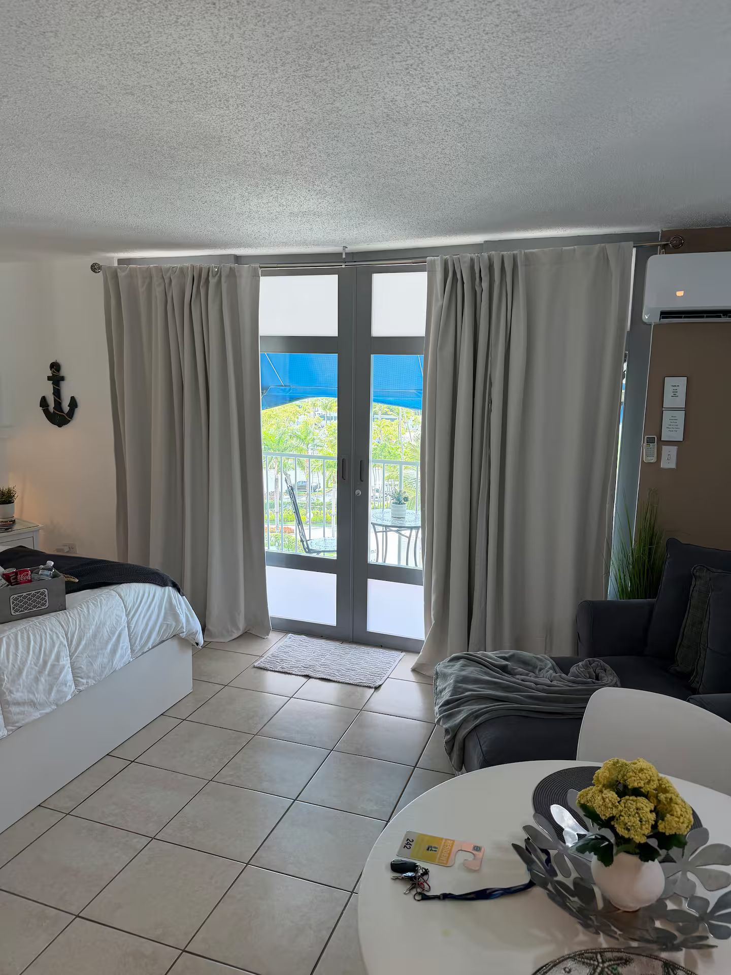 Une chambre d ’hôtel avec un lit, un canapé, une table à manger et un balcon avec vue.