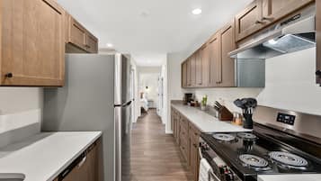 A modern kitchen with wooden cabinets, stainless steel appliances, and a central island.