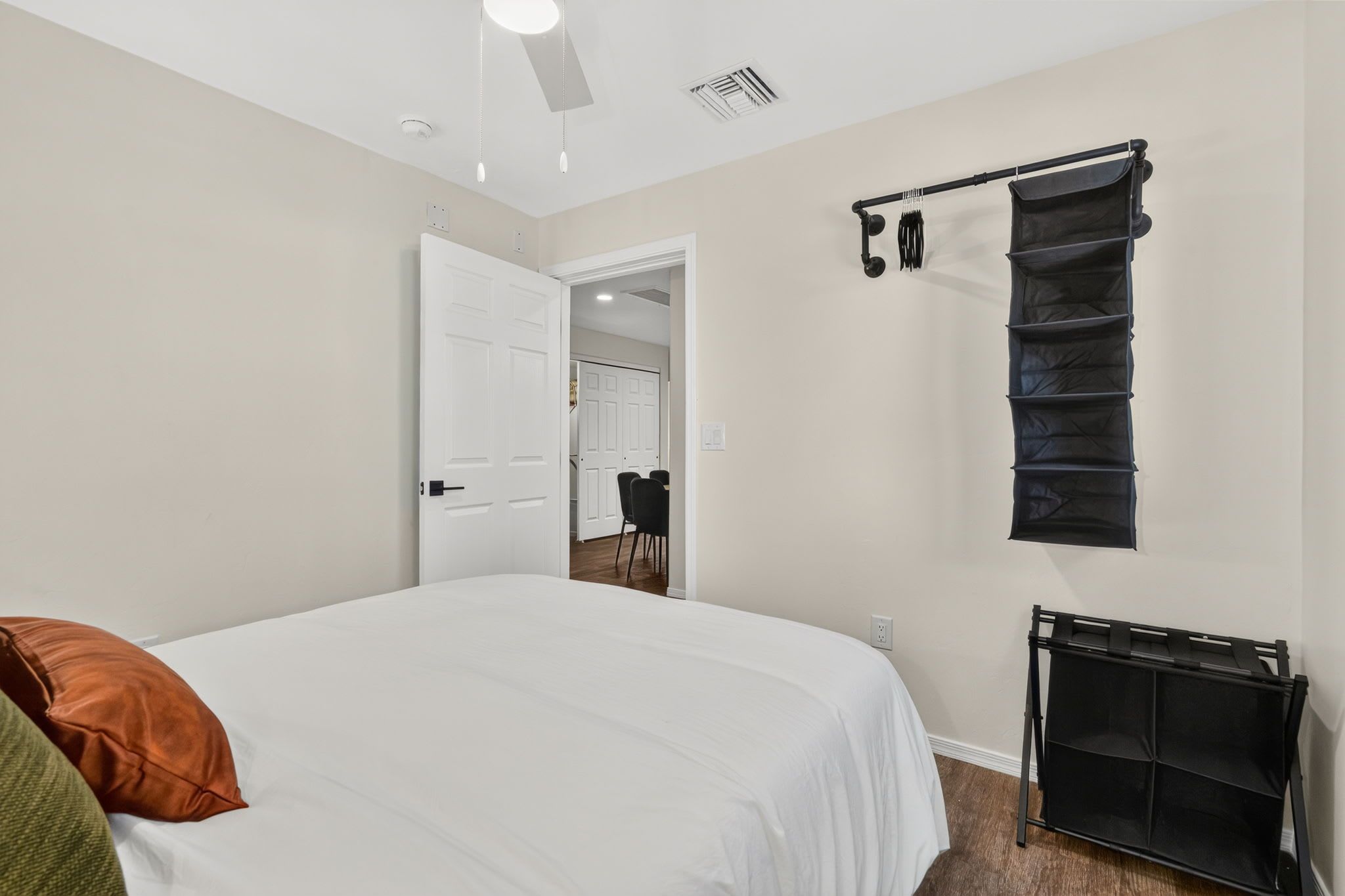 Un dormitorio con una cama grande, un armario y una puerta que da a otra habitación.