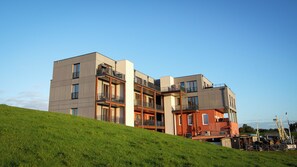 A multi-story residential building with balconies and a sloped roof. - Sea and Sky Pellworm—Exclusive Penthouse with a 300° View of the Wadden Sea (Pellworm)