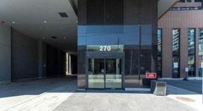 A modern building entrance with a glass door marked '270' and a red sign indicating a no-parking zone. - Fully furnished condo in King West, perfect for 30+ night stays (Toronto)