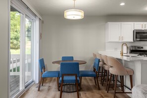 A modern kitchen with white cabinets, a stainless steel microwave, and a gas stove. - The Irish Landing | 2BR/2BA | Private Balcony (South Bend)