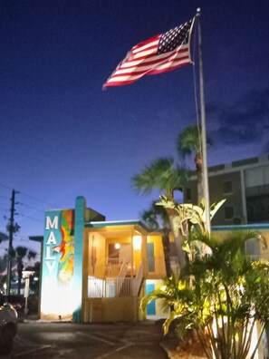 A building with a sign that reads 'MALY' and an American flag. - Unit 117 - Comfy Island Treasure (Ground Floor) (Treasure Island)