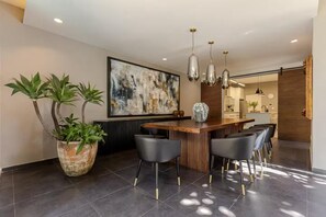 A modern kitchen with a bar area, potted plants, and a large abstract painting on the wall. - Beautiful villa with a garden in the center of San Pedro Tlaquepaque, a “Pueblo Mágico”   (San Pedro Tlaquepaque)